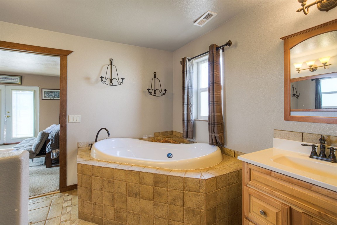 73 Mid Land Avenue Hartsel, CO 80449 - Photo 13 of 31 a bathroom with a tub sink and mirror