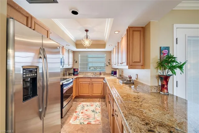 a kitchen with stainless steel appliances granite countertop a sink a stove and a refrigerator