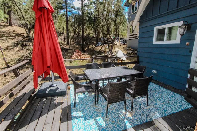 a view of a deck with table and chairs with wooden floor and fence