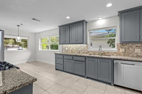 a kitchen with granite countertop a sink and a stove