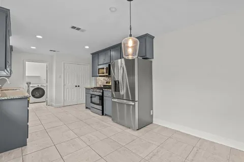a kitchen with stainless steel appliances a refrigerator and a stove top oven