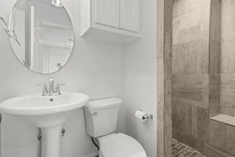 a bathroom with a sink a toilet and shower