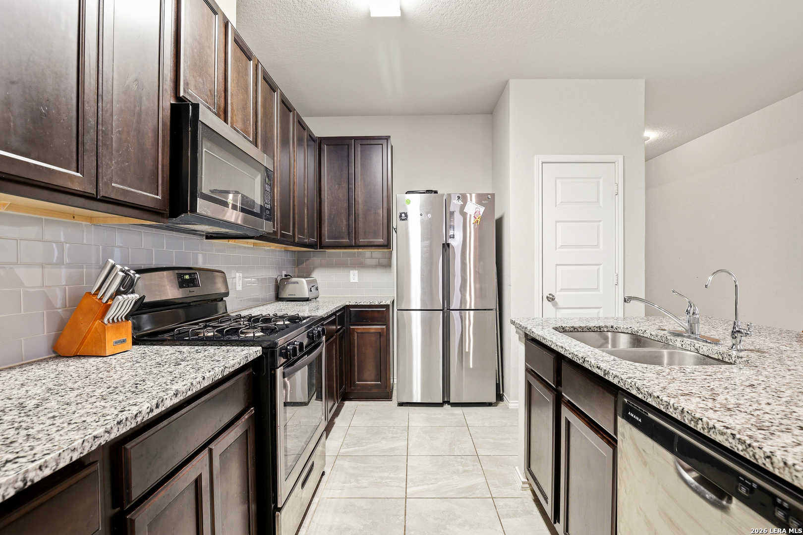 5314 Riley Way St. Hedwig, TX 78152 - Photo 12 of 26 a kitchen with stainless steel appliances granite countertop a sink stove and refrigerator