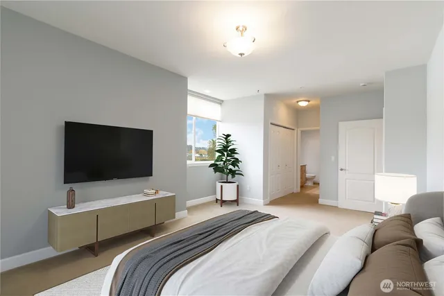 a bedroom with a bed and a flat screen tv