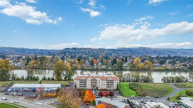 an aerial view of a city with lots of residential buildings lake and mountain view in back