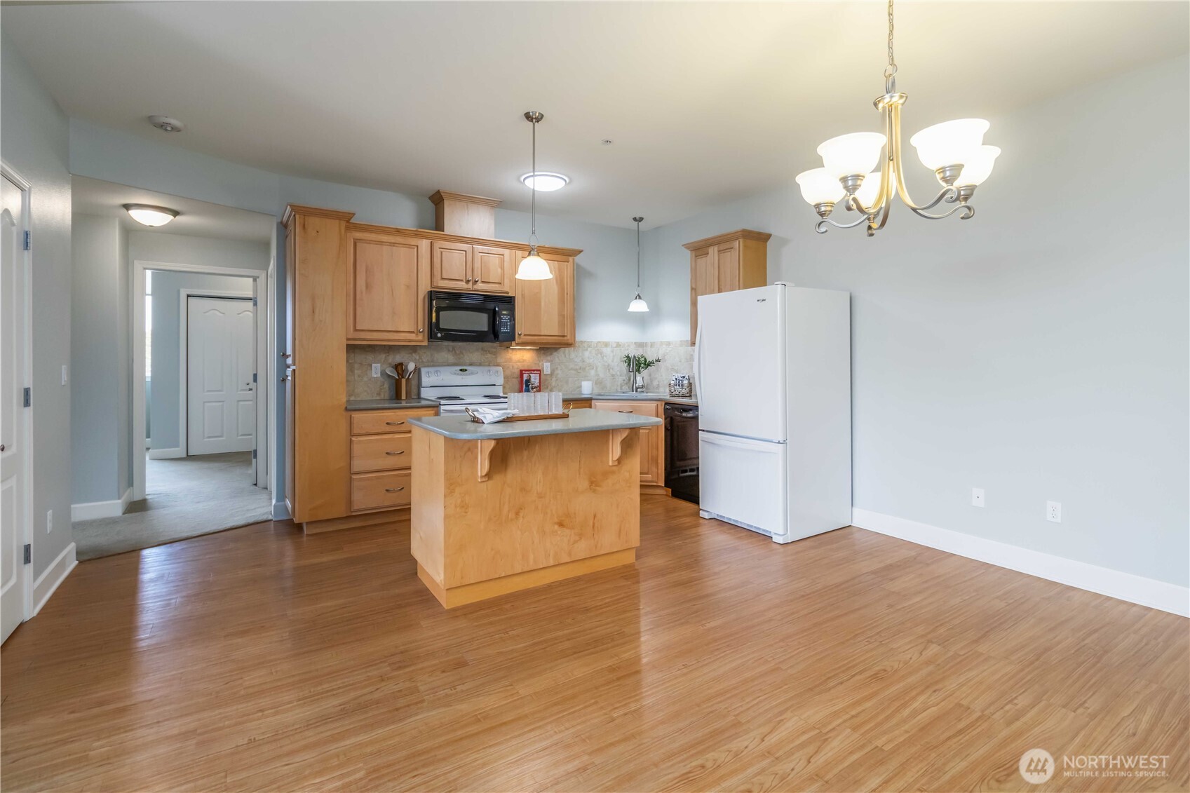1548 River Road, Unit 302 Longview, WA 98632 - Photo 7 of 37 a kitchen with stainless steel appliances granite countertop a stove a refrigerator a oven a sink with a dining table and chairs