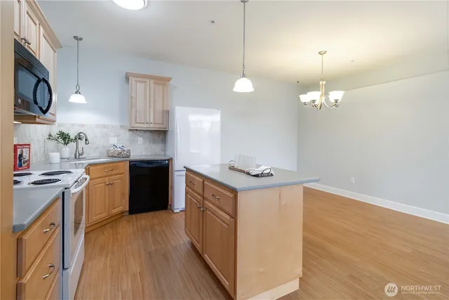 a kitchen with stainless steel appliances granite countertop a sink a stove and a wooden floors