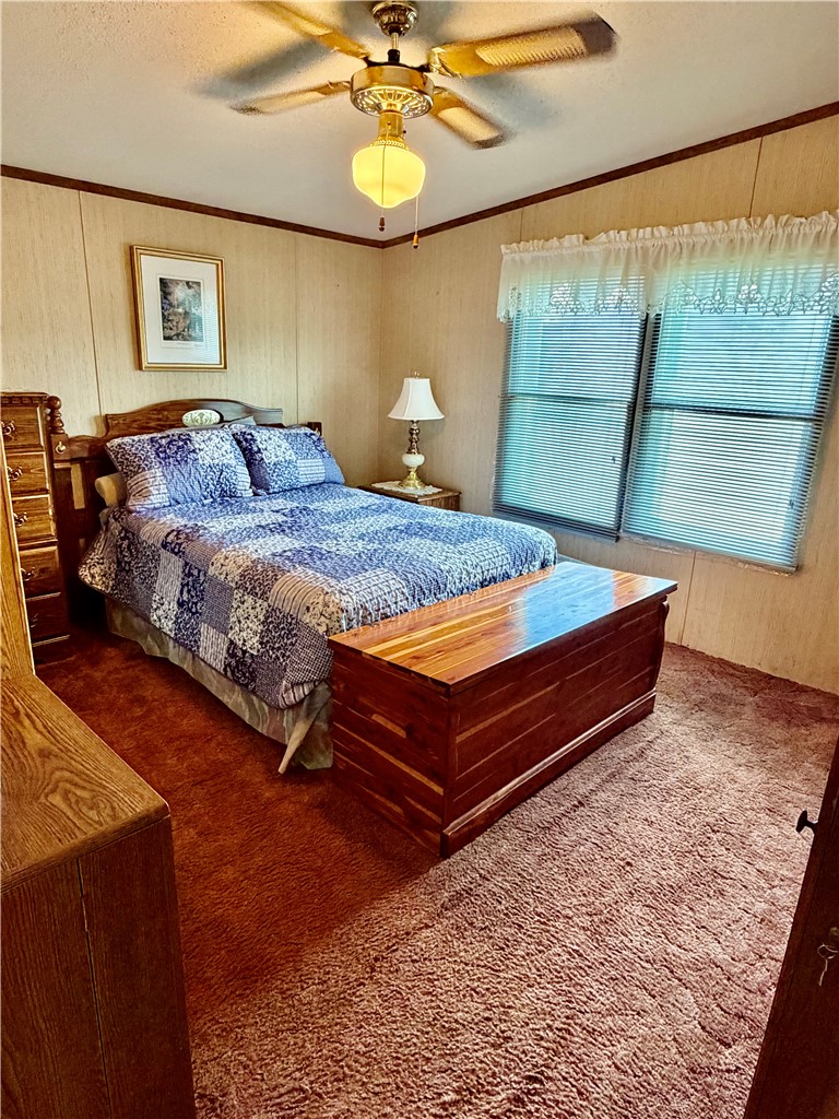 1549 Greenfield Road Westminster, SC 29693 - Photo 32 of 49 A comforting bedroom space features warm wall paneling and plush carpeting underfoot.