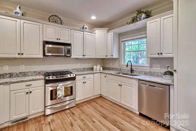a kitchen with granite countertop cabinets stainless steel appliances and a window