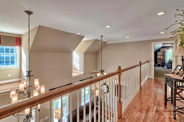 a view of hallway with stairs and wooden floor