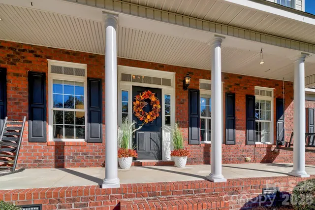 a kitchen with granite countertop a refrigerator a stove a dining table and chairs with wooden floor