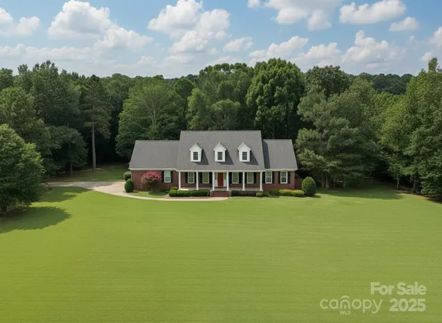 an aerial view of a house with swimming pool and garden