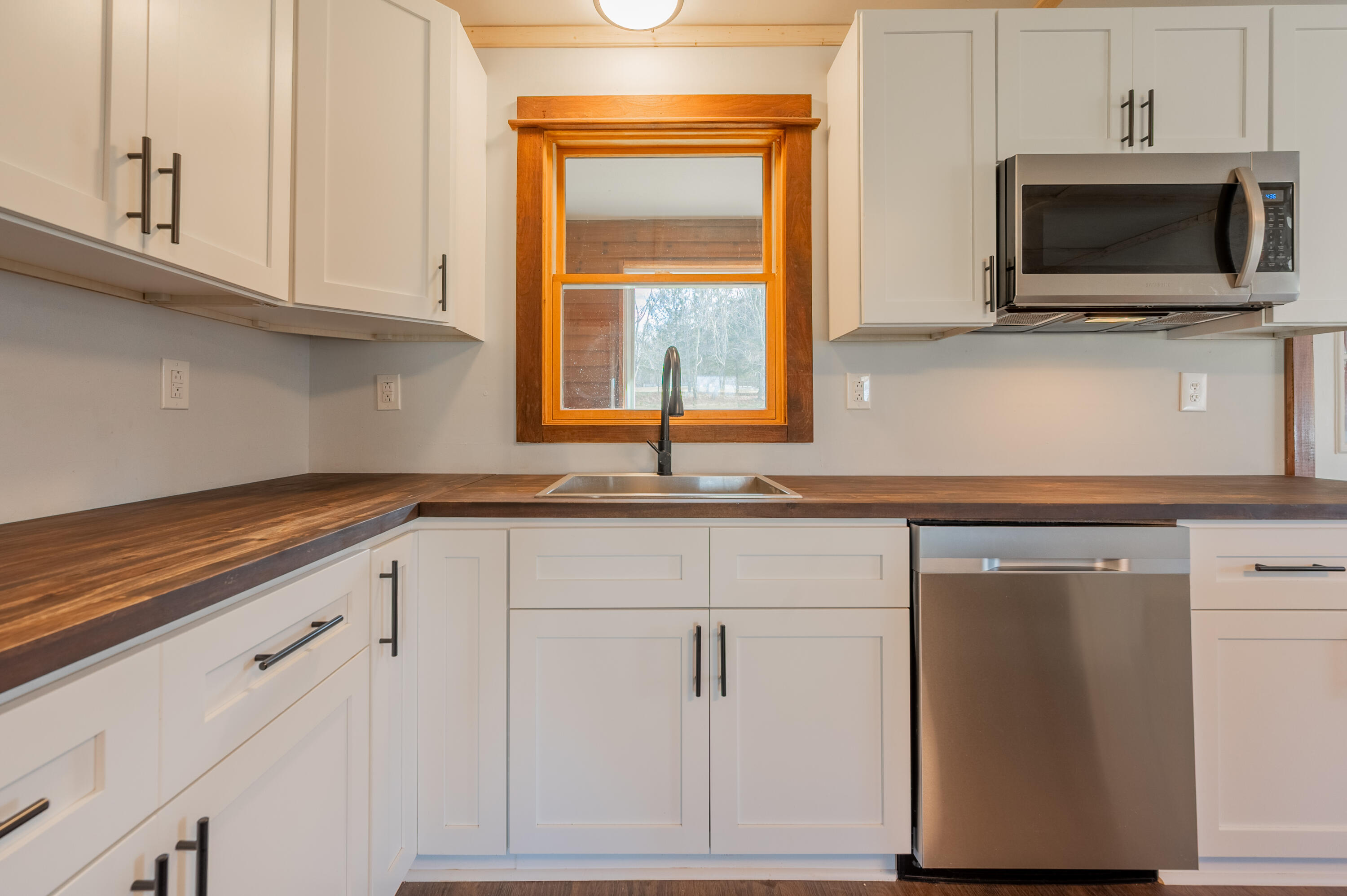 1133 Countyline Church Road Southeast Floyd, VA 24091 - Photo 27 of 97 a kitchen with granite countertop white cabinets stainless steel appliances and a window