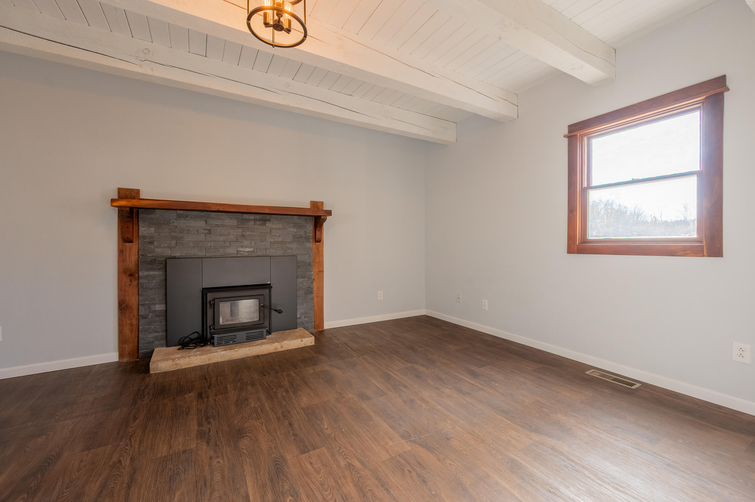1133 Countyline Church Road Southeast Floyd, VA 24091 - Photo 42 of 97 an empty room with wooden floor a fireplace and windows