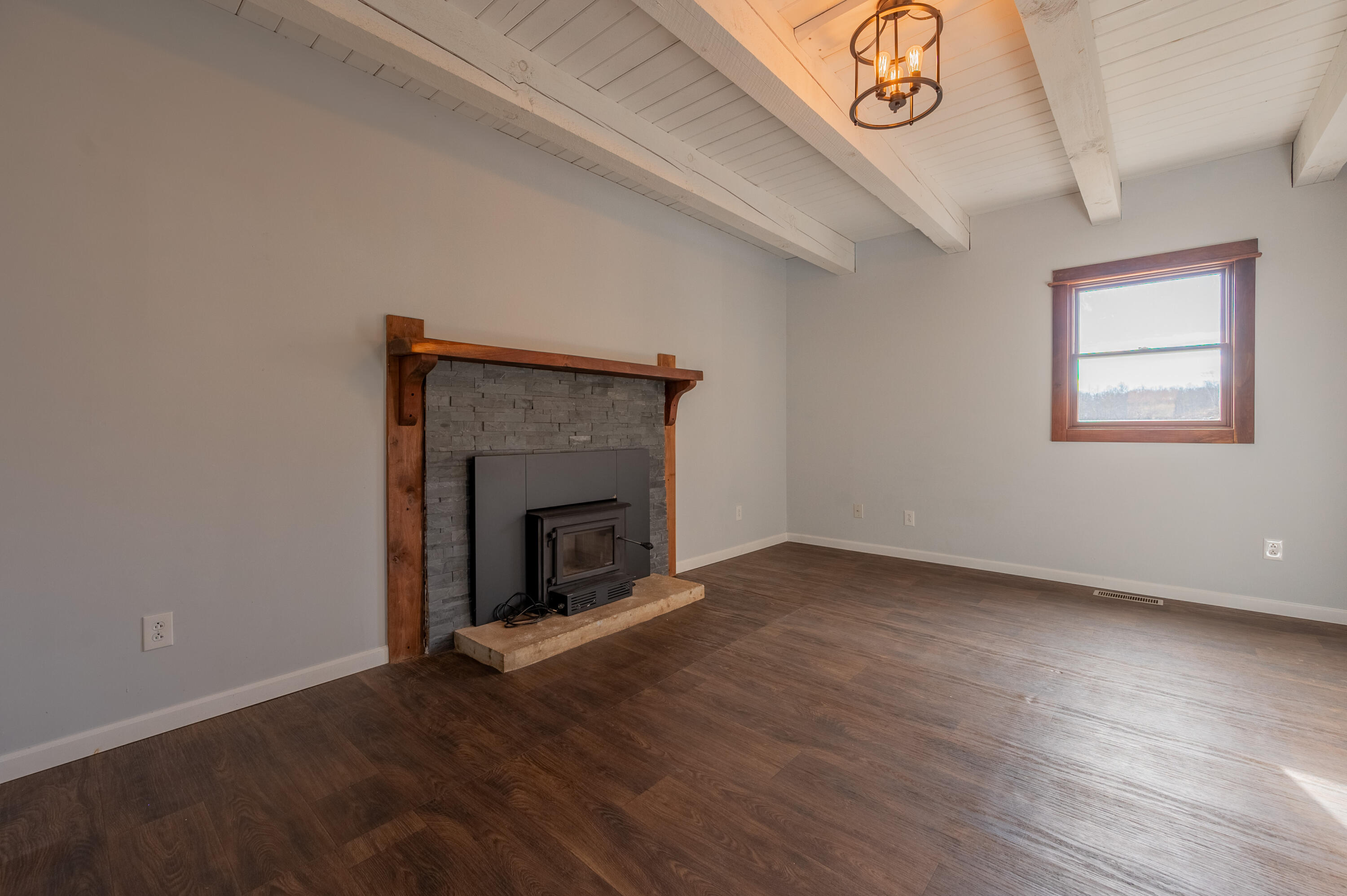 1133 Countyline Church Road Southeast Floyd, VA 24091 - Photo 43 of 97 an empty room with wooden floor a fireplace and windows