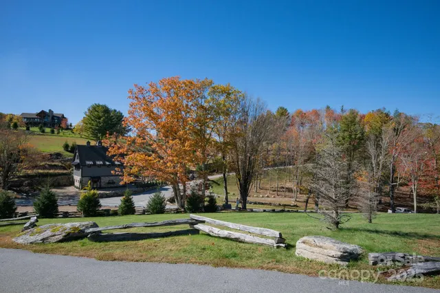 a view of a house with a big yard and large trees