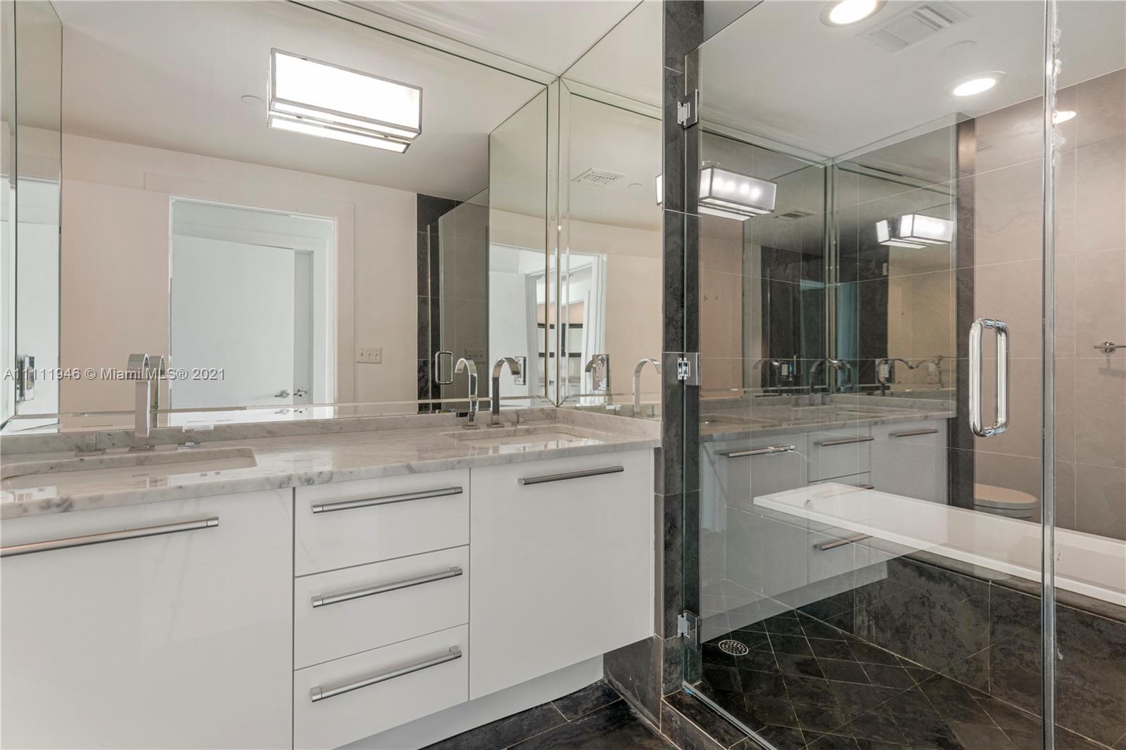 900 Biscayne Boulevard, Unit 507 Miami, FL 33132 - Photo 11 of 20 a bathroom with a granite countertop sink mirror and toilet