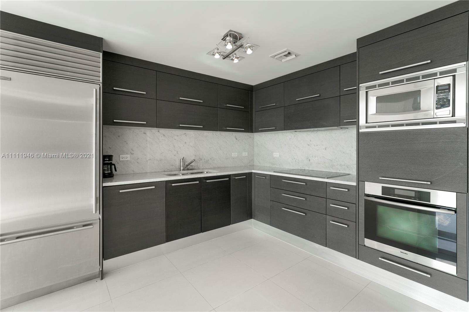 900 Biscayne Boulevard, Unit 507 Miami, FL 33132 - Photo 4 of 20 a kitchen with granite countertop cabinets and steel stainless steel appliances