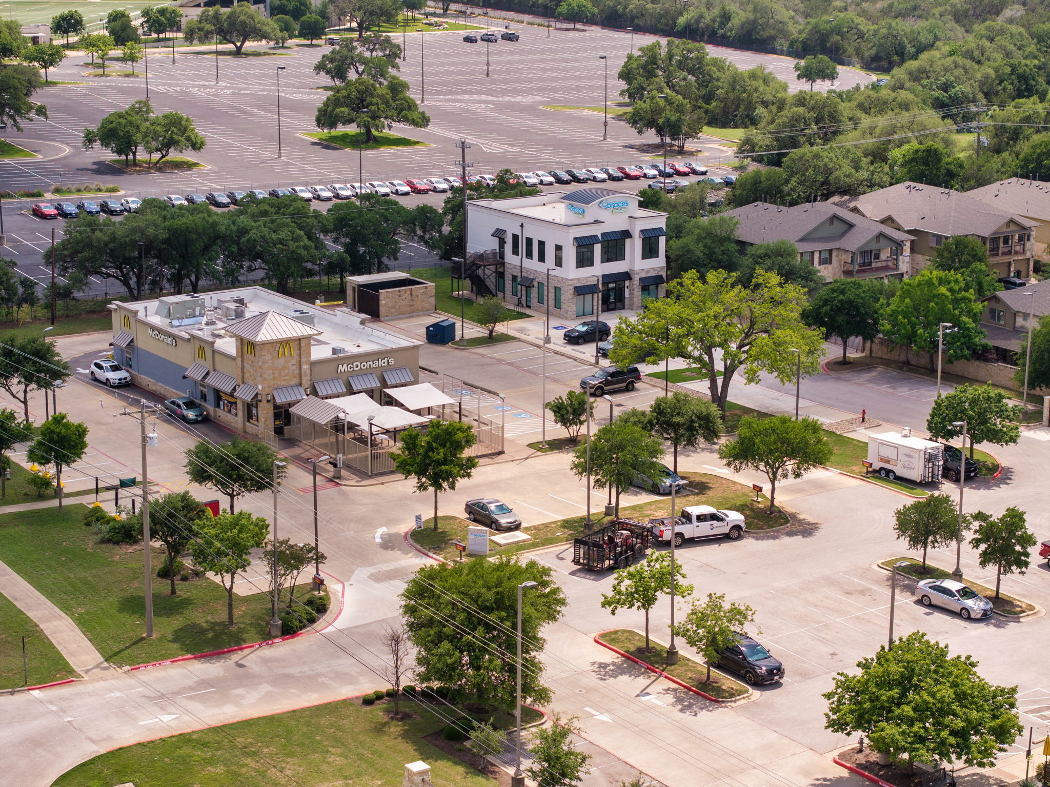 14815 Avery Ranch Boulevard, Unit 1401 Austin, TX 78717 - Photo 35 of 38 Commercial property featuring a stone and stucco exterior, multiple entry points, and an outdoor patio area with awnings
