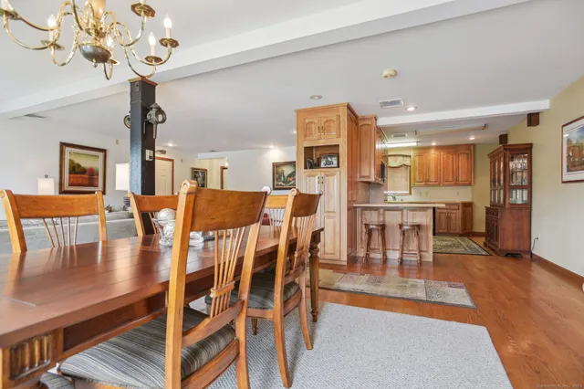a view of a dining room with furniture a chandelier and wooden floor