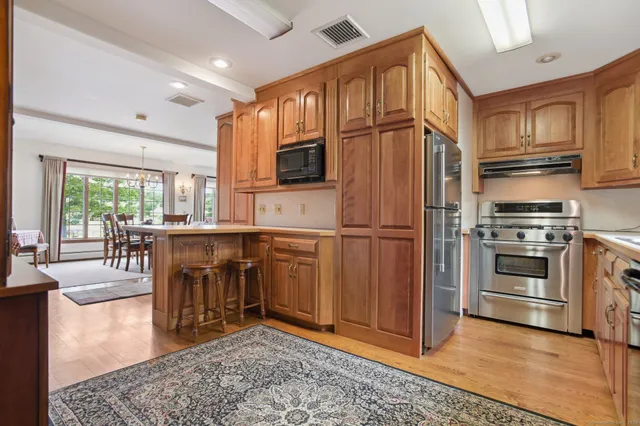 a kitchen with stainless steel appliances granite countertop a refrigerator stove top oven and sink