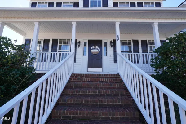 a view of a brick house with deck and windows