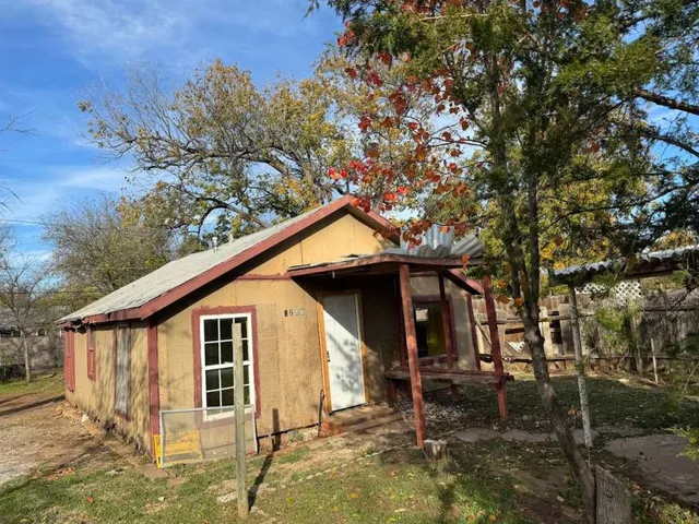 a backyard of a house with table and chairs