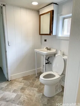 a bathroom with a toilet a sink and a mirror
