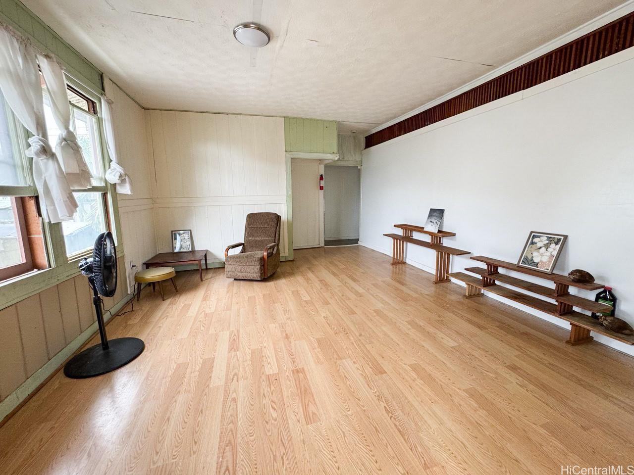 82 Hoku Street, Unit D Hilo, HI 96720 - Photo 2 of 15 a bedroom with furniture and a wooden floor