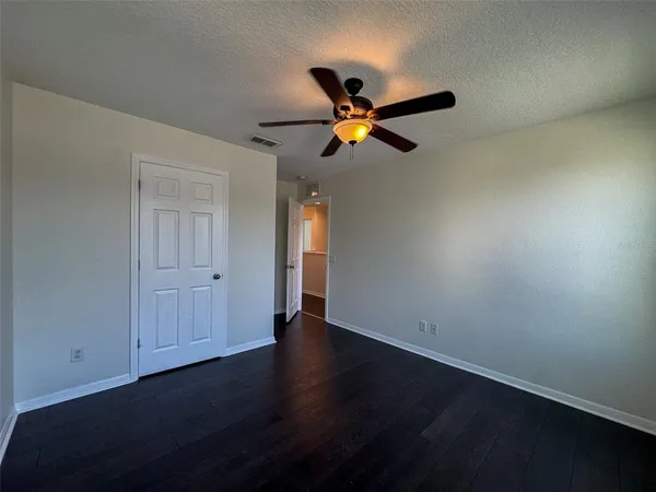 an empty room with a window and a ceiling fan