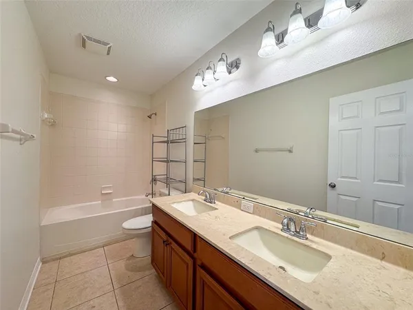 a bathroom with a sink double vanity granite tub shower and a mirror
