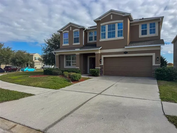 a front view of a house with yard and garage