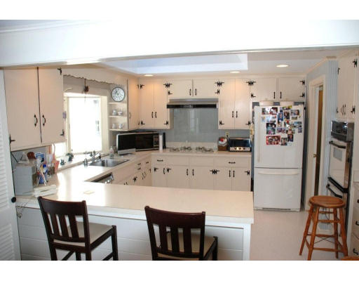 94 Sears Road Wayland, MA 01778 - Photo 4 of 6 a kitchen with stainless steel appliances kitchen island granite countertop a refrigerator a stove a sink dishwasher and white cabinets with wooden floor