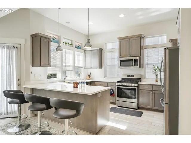 a kitchen with stainless steel appliances kitchen island granite countertop a sink and cabinets