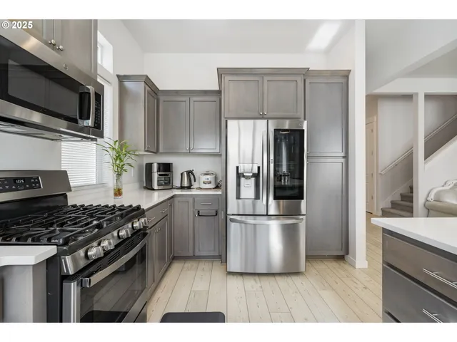 a kitchen with kitchen island stainless steel appliances a sink a stove and cabinets