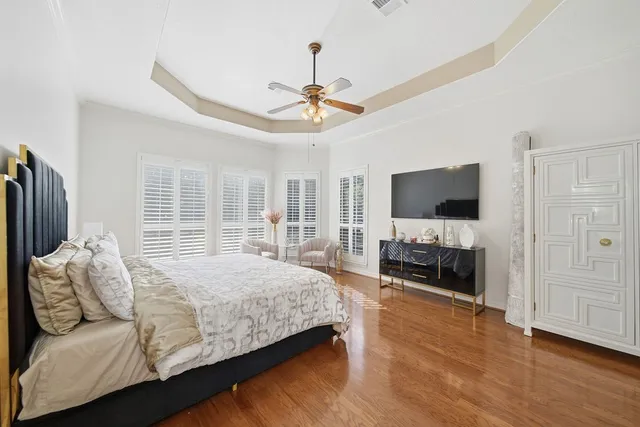a bedroom with a bed television and a large window
