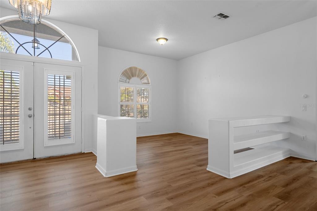 7285 Nightwalker Road Weeki Wachee, FL 34613 - Photo 9 of 79 an empty room with wooden floor cabinet and windows