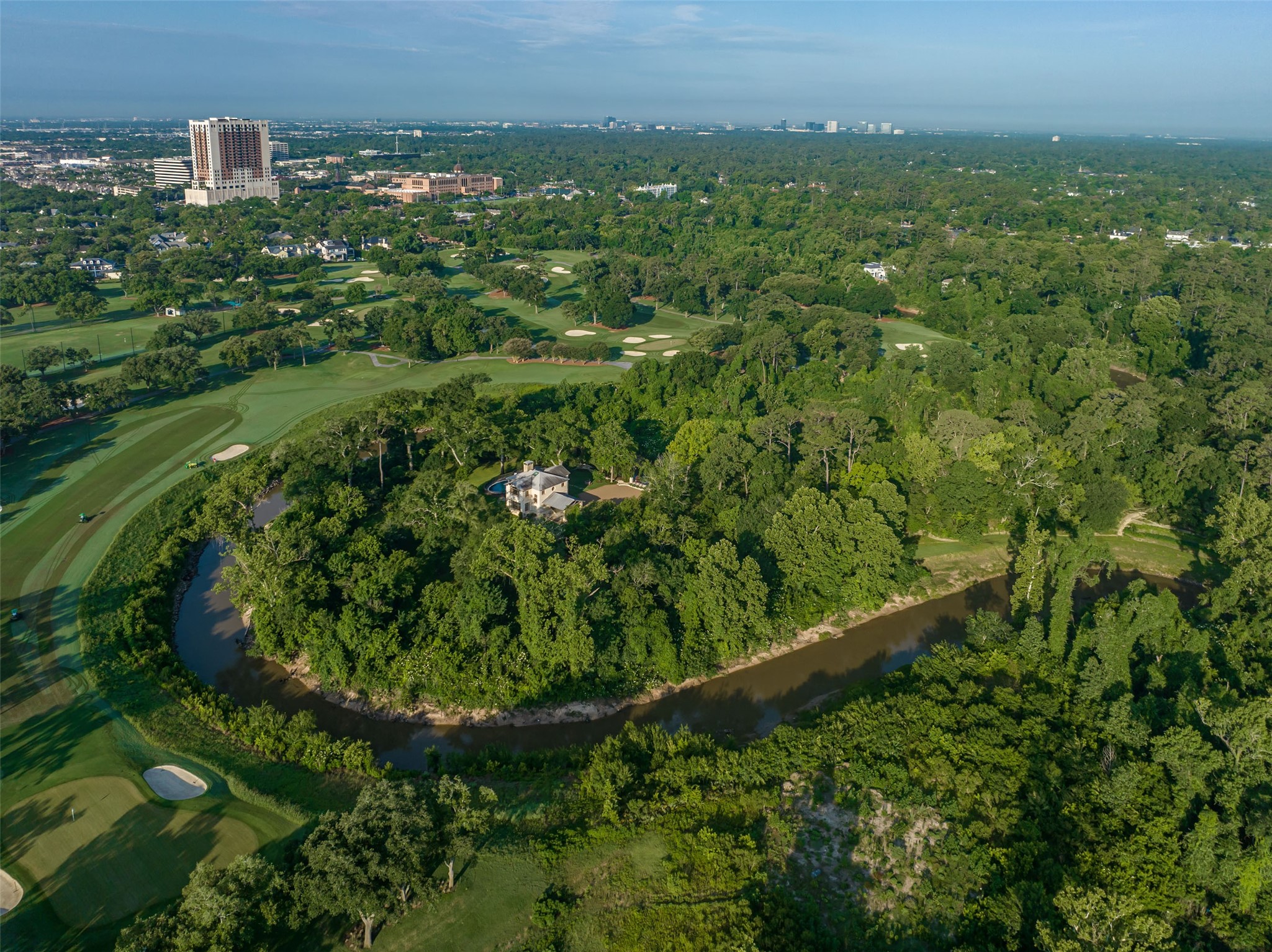 107 Timberwilde Lane Houston, TX 77024 - Photo 32 of 40 From above, the guest house is revealed as a serene outpost—secluded in a forest of trees, surrounded by water, and set high on a fortified, reinforced peninsula. Elevated above the golf greens, it offers commanding views, enduring strength, and rare exclusivity.