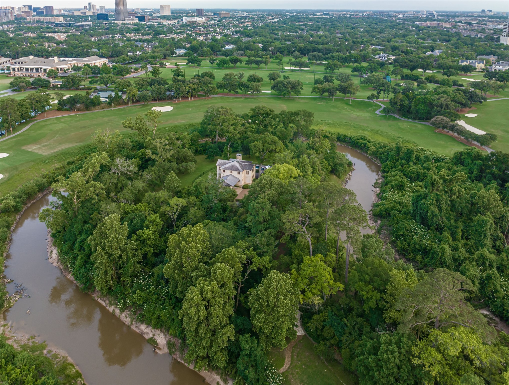 107 Timberwilde Lane Houston, TX 77024 - Photo 33 of 40 This aerial view highlights the guest house set at the tip of the nine-acre peninsula, secured by a fortified shoreline. Along Buffalo Bayou, a reinforced bulkhead of concrete and steel sheet piling has been engineered around the entire perimeter. This vital infrastructure enhances the estate’s natural defenses, preserves its rare and valuable setting, and ensures long-term structural integrity for generations to come.