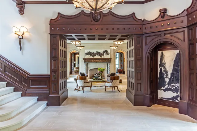a view of a livingroom with a fireplace a chandelier and wooden floor