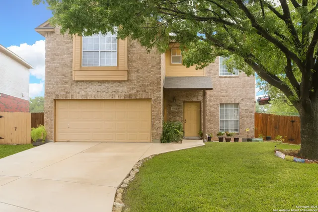 a front view of a house with a yard and trees
