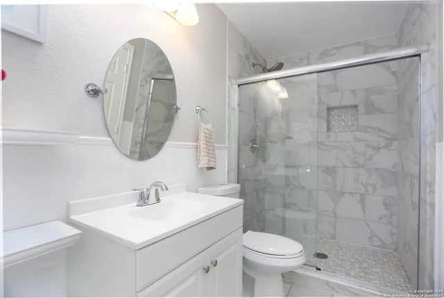 a bathroom with a sink a toilet and a mirror