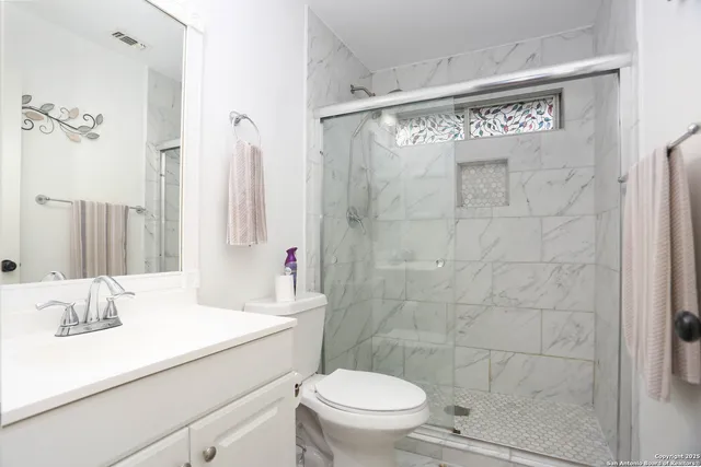 a bathroom with a sink a toilet and shower