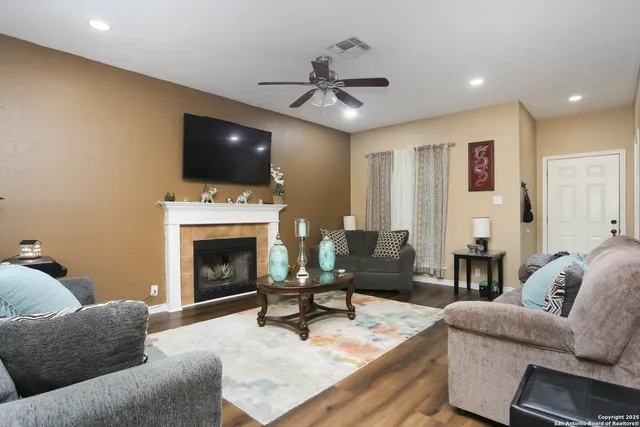 a living room with furniture a flat screen tv and a fireplace
