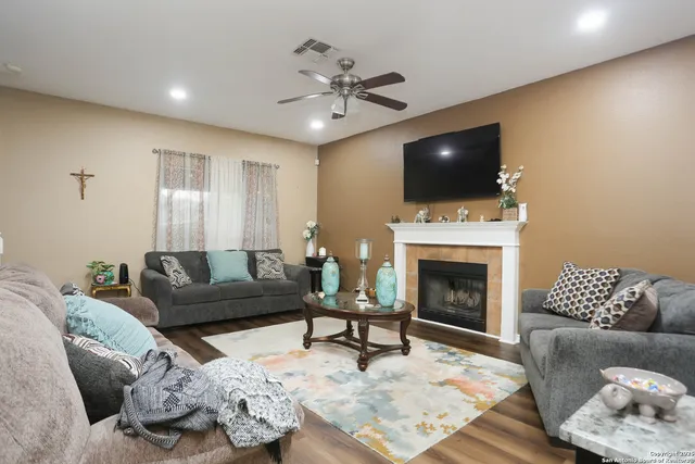 a living room with furniture a flat screen tv and a fireplace