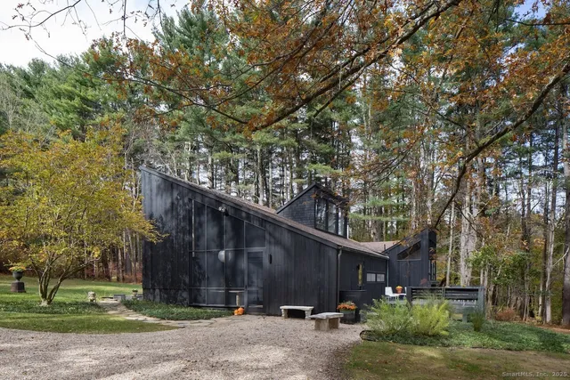 a front view of a house with a large tree