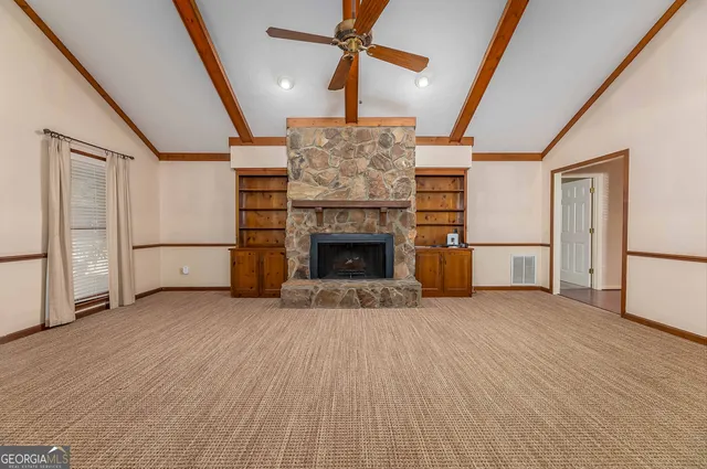 a view of empty room with wooden floor and fireplace