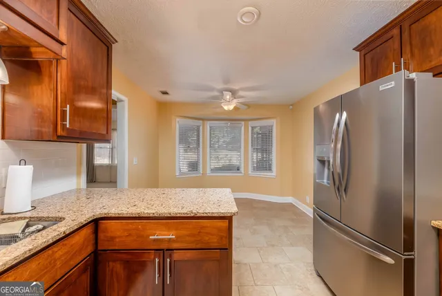 a kitchen with stainless steel appliances granite countertop a refrigerator and a sink