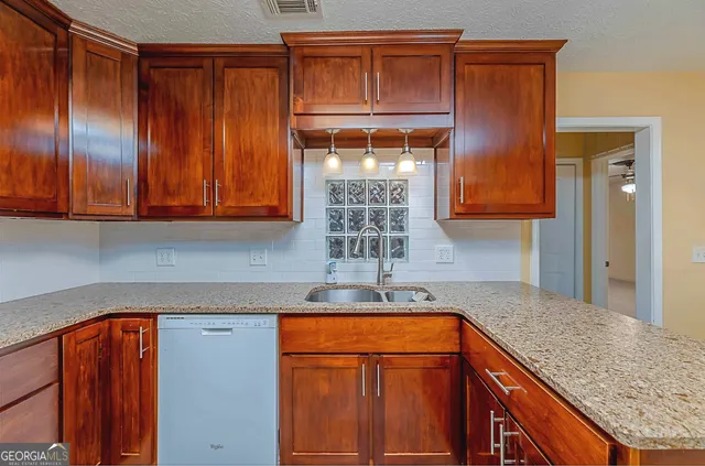 a kitchen with stainless steel appliances granite countertop wooden cabinets a sink and dishwasher