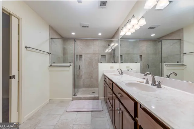 a bathroom with a sink a faucet a mirror and a shower